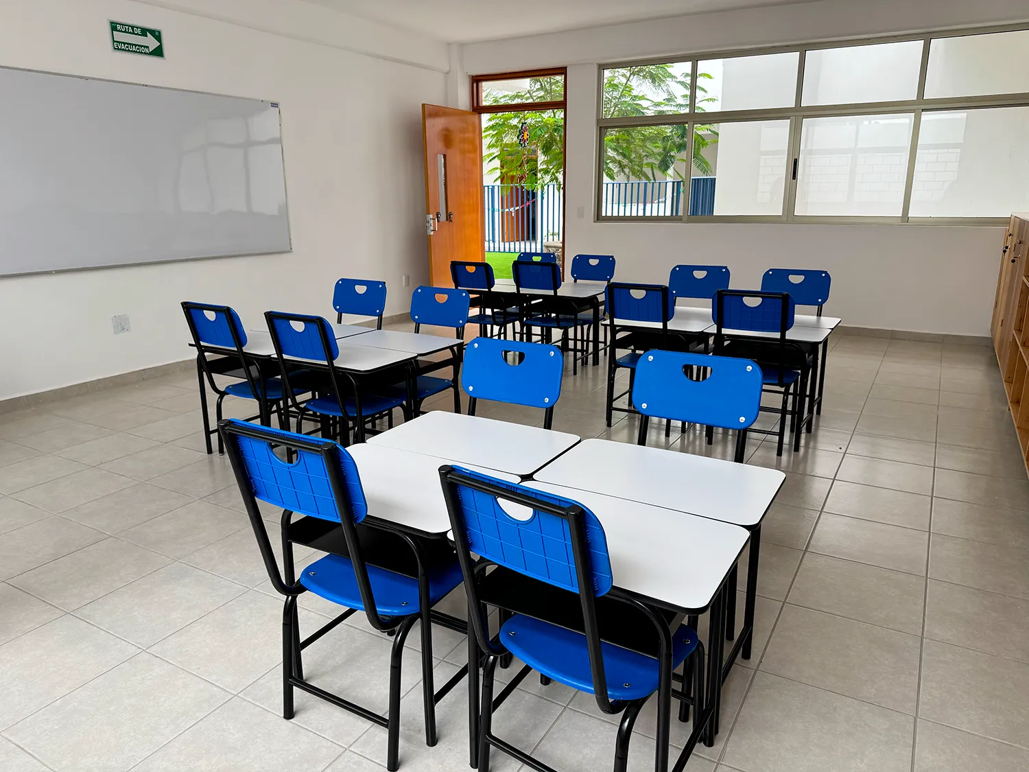 Salón del Instituto Quetzal con mesas agrupadas para trabajar en equipo